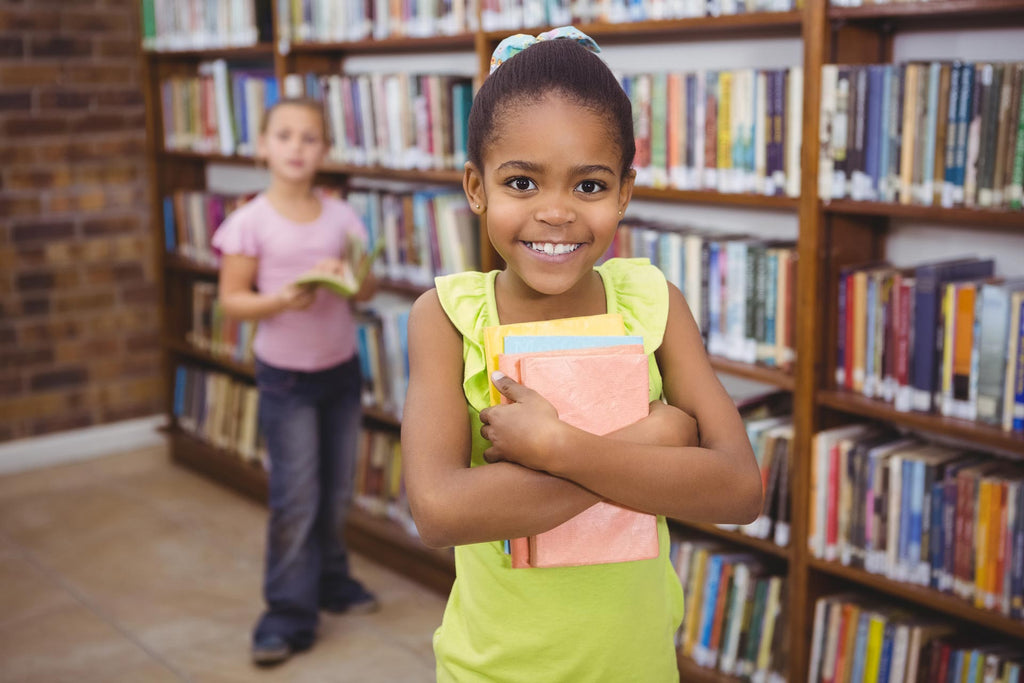 young girl smiling holding books